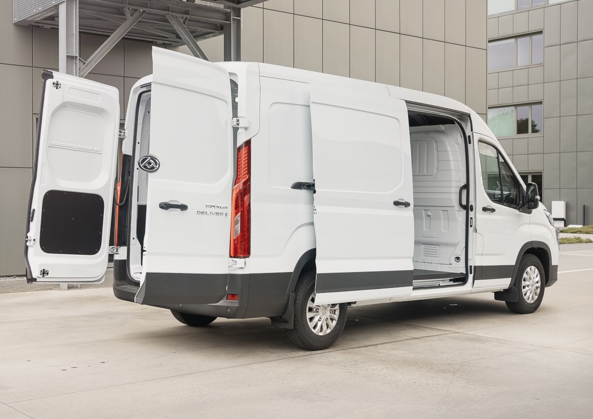 Weißer Transporter mit offenen Türen, stehend vor einem modernen Gebäude, ideal für Lieferungen und Transport.